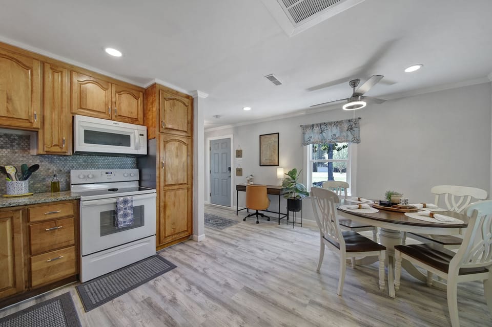 Photo showing kitchen, dining table, work area, and front door.