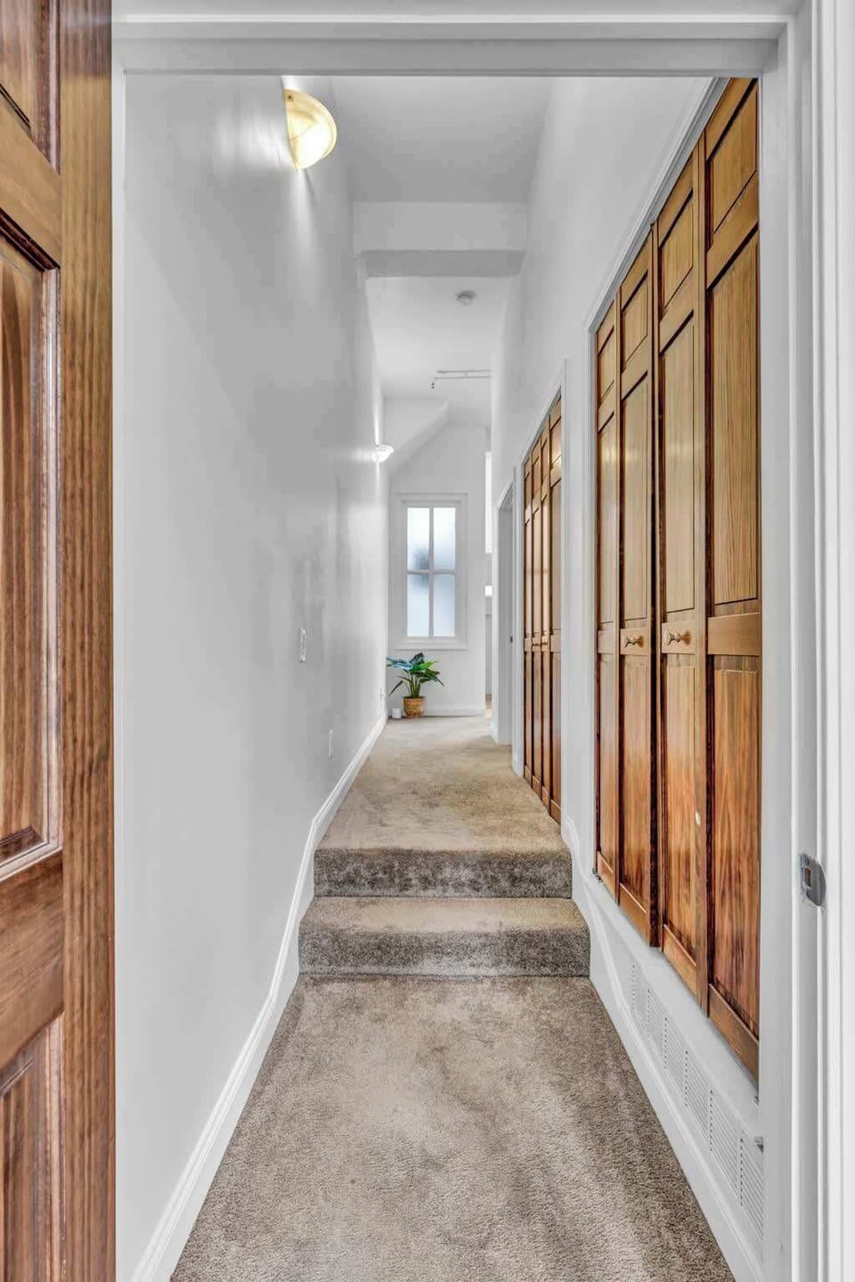 Step into a hallway adorned with plush carpeting, promising comfort with every stride. Natural wood doors mark the way, concealing treasures within the supply closet.