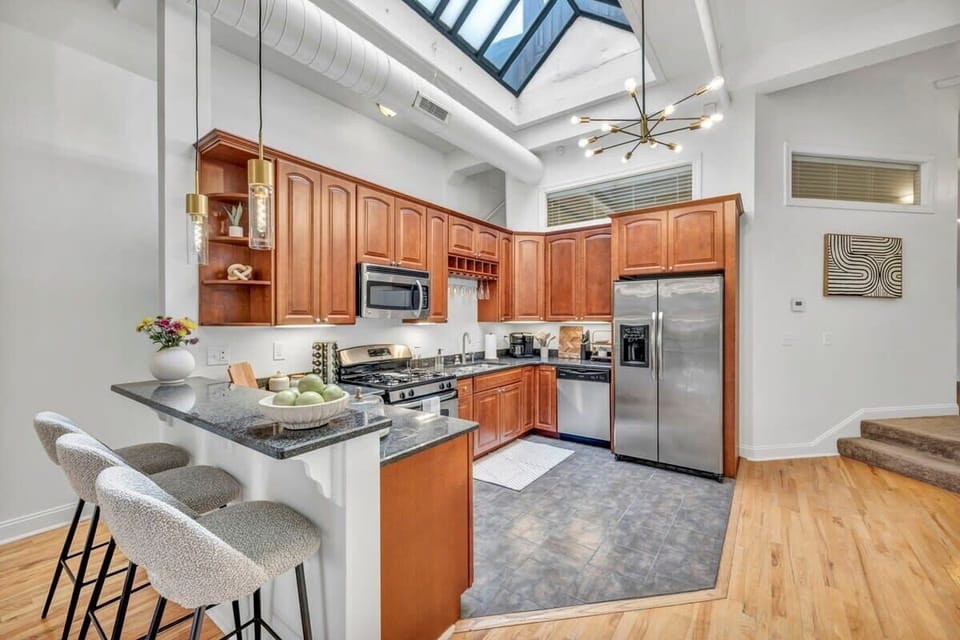 In the open kitchen, natural light pours in from high ceilings, accentuating the modern-meets-country vibe. Natural wood cabinets add warmth, while sleek granite countertops bring contemporary flair. It's a captivating blend of styles that invites you to cook and create amidst the perfect harmony of comfort and sophistication.