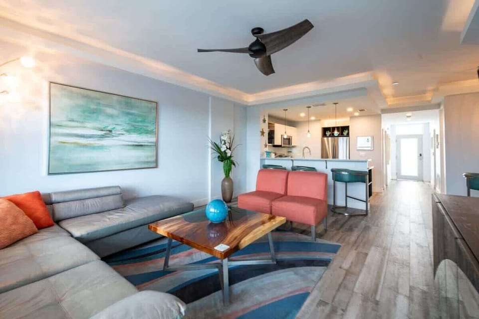 Modern living room with a sectional sofa, wood coffee table, and open kitchen layout.