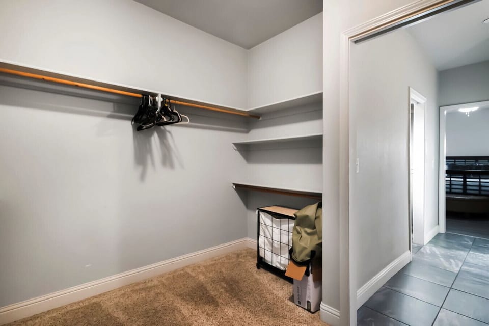 Additional generous storage space featuring wrap-around shelving and overhead hanging rods.