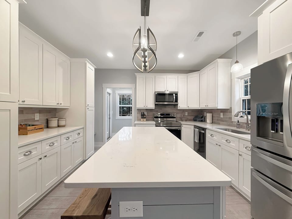 Bright chef’s kitchen with quartz island, SS appliances, ample storage
