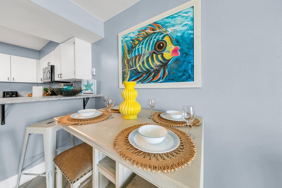 Dine surrounded by vibrant coastal art in your charming eating nook, where tropical fish artwork sets the mood for memorable meals.