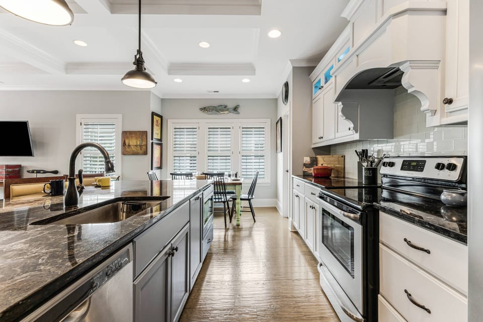 Natural lighting from the windows, pendant lights & the can lights make preparing meals enjoyable in this light & airy space.