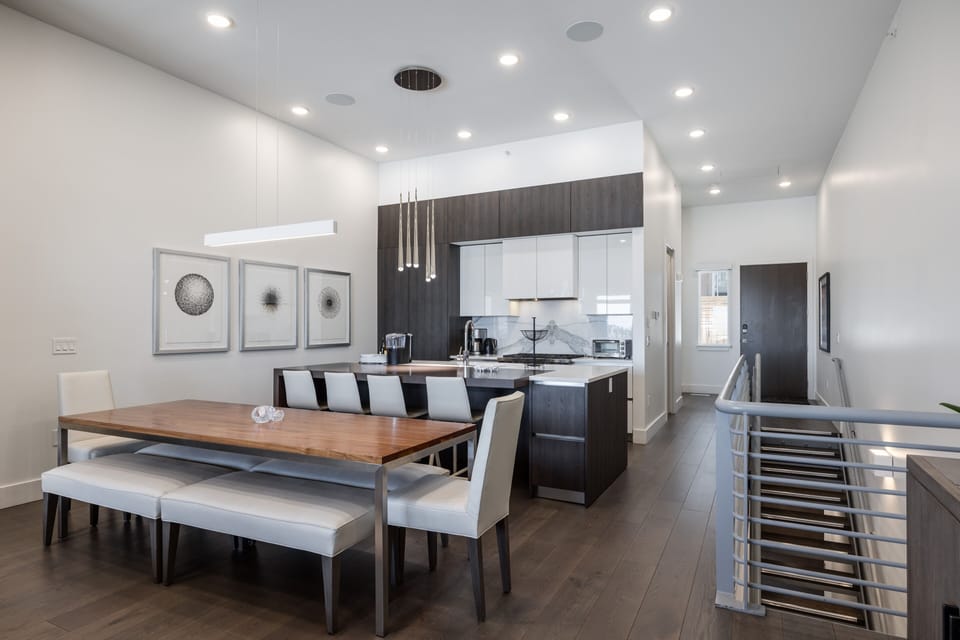 - Spacious dining area with long wooden table and bench seating  
- Kitchen island with modern pendant lighting and sleek finishes  
- Open layout designed for meals and après-ski entertaining