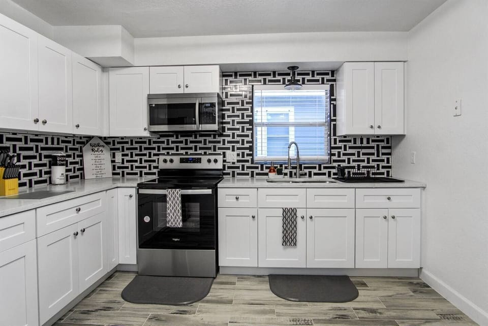 The kitchen is modern and elegant, with designer cabinets. It is a spacious area with lots of light.