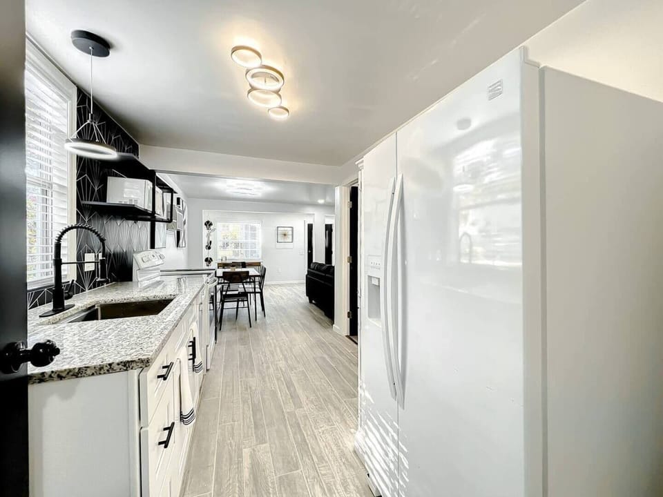 The kitchen is fully equipped with a 4-burner stove, an oven, and a microwave for added convenience. It features spacious cabinets that provide plenty of storage space and a large refrigerator.