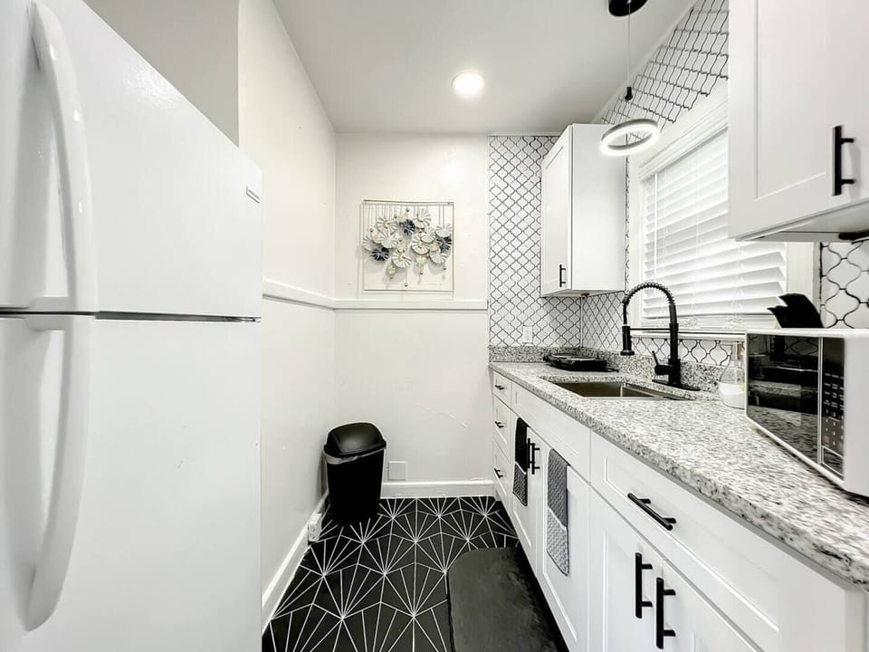 The kitchen is compact and functional, equipped with a two-burner stove, a microwave, and spacious cabinets that provide ample storage space.