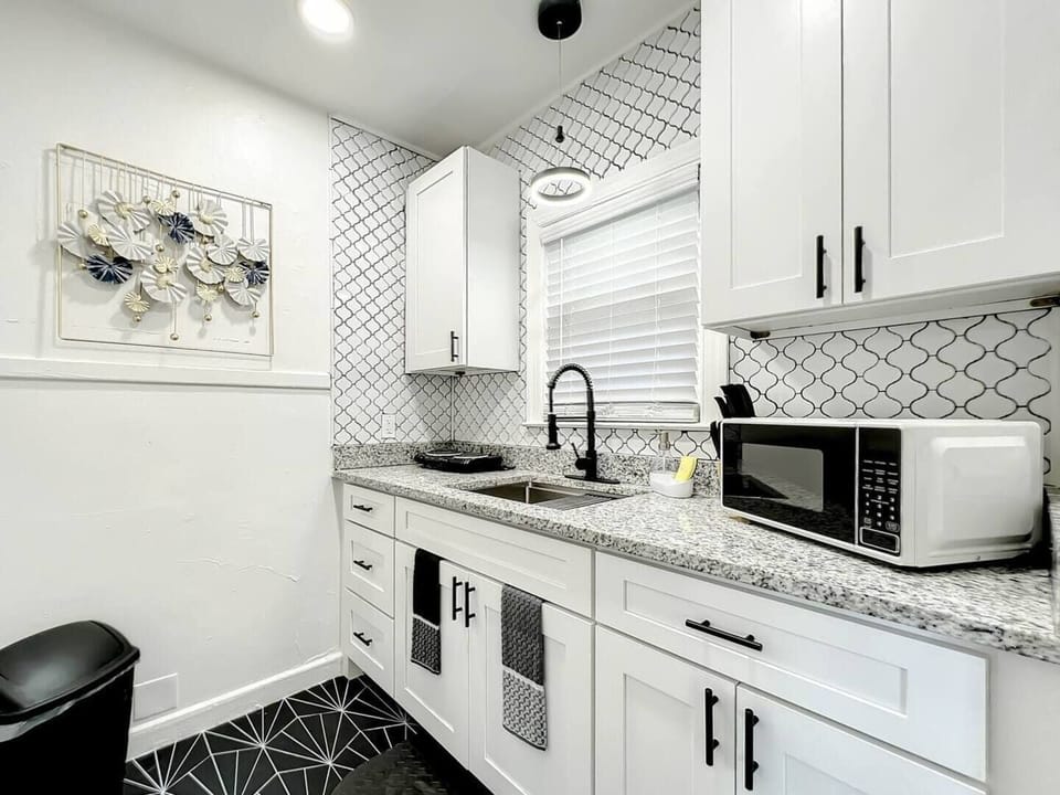 The kitchen is compact and functional, equipped with a two-burner stove, a microwave, and spacious cabinets that provide ample storage space