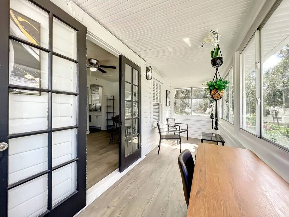 The enclosed balcony is a cozy and bright space, perfect for working or relaxing. It features a desk, ideal for use as a workspace or study area. Large windows surround the balcony, allowing natural light to enter and offering views of the outside.