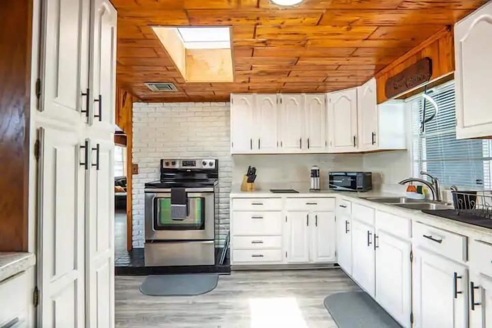 Spacious kitchen featuring a 4-burner stove with an oven and ample cabinets for storage.