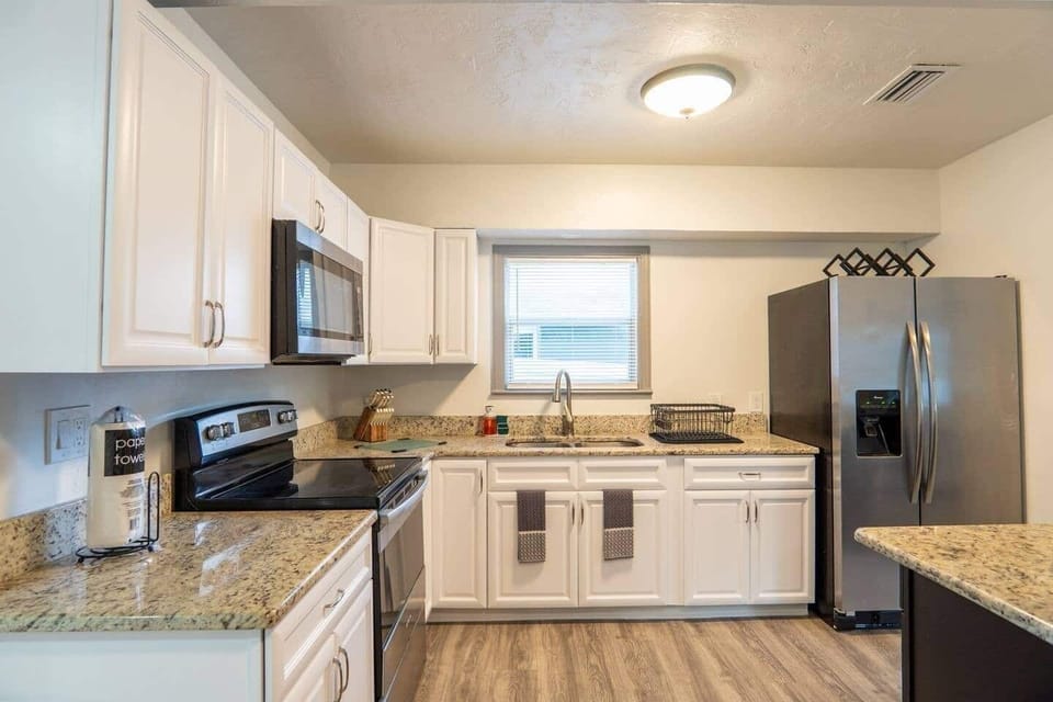 Kitchen with a 4-burner stove, microwave, large refrigerator, and plenty of cabinets for storage.