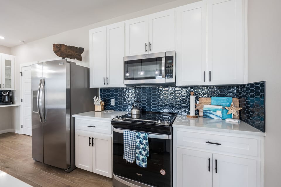 Kitchen - Sleek stainless steel appliances complement the kitchen’s modern coastal design.