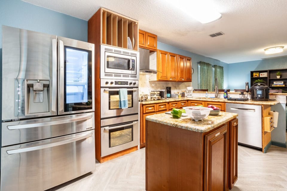 Stylish stainless steel appliances including double oven and instaview fridge.