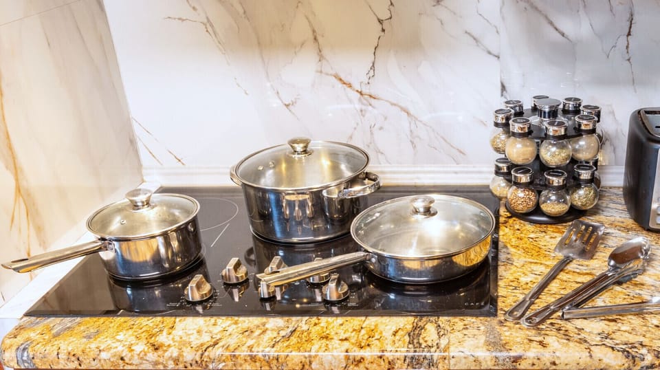 Stainless steel cookware, glass-top stove with PowerBoil, and a full spice rack.