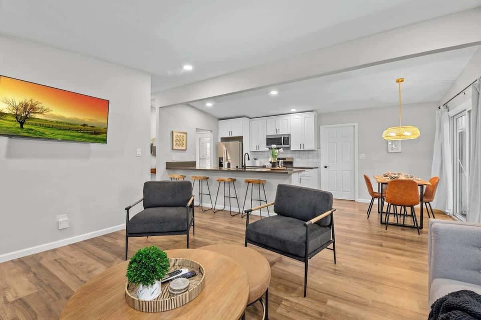 Modern open-concept living space with a sleek kitchen, cozy dining area, and stylish lounge. Neutral tones, warm lighting, and contemporary furnishings create a welcoming and elegant atmosphere for relaxation.