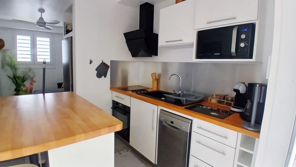 Modern, fully equipped kitchen with a dishwasher, oven, microwave and dining area, for a comfortable stay.