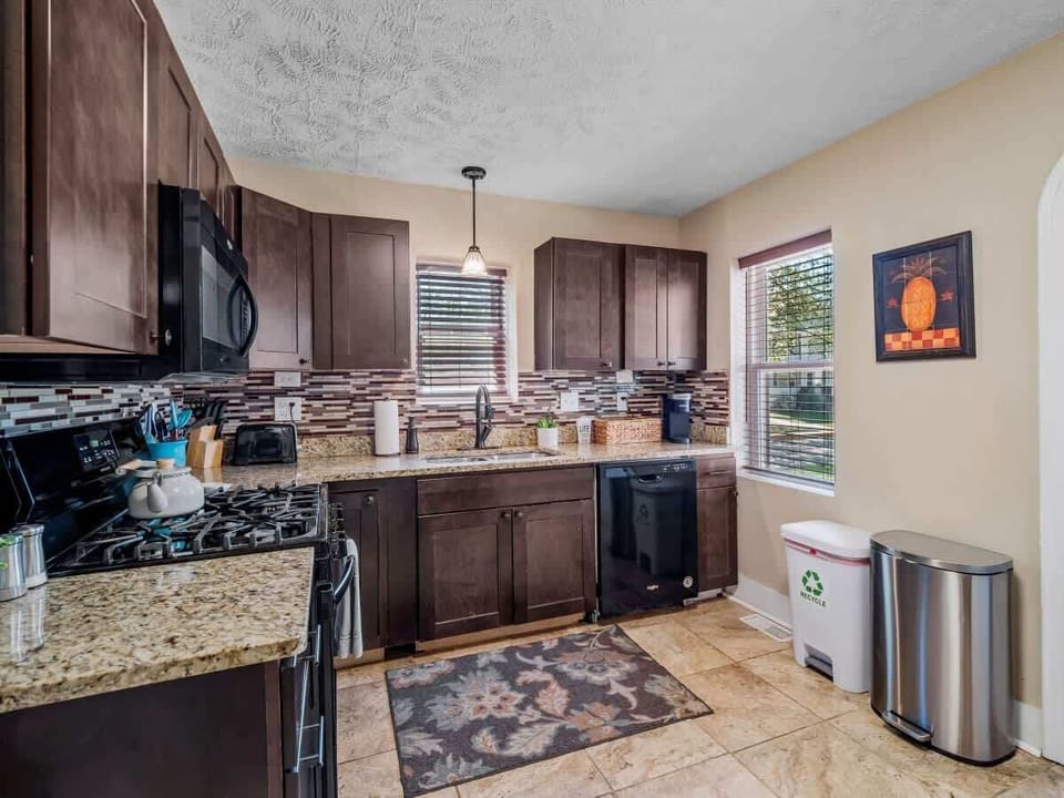 Modern kitchen  with granite countertops, stylish backsplash, and full-size appliances. Perfect for cooking up your favorite meals or enjoying morning coffee ☕.