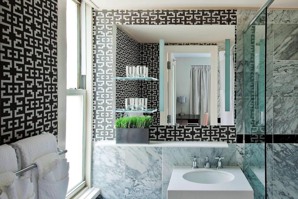 Refresh at a chic marble vanity with bright natural light.