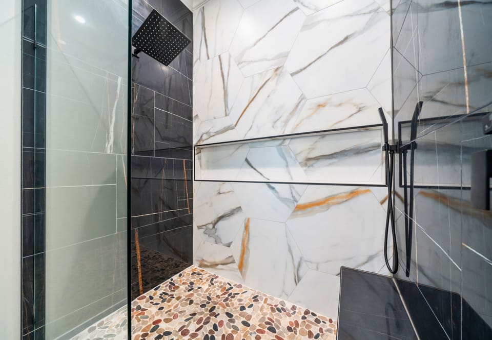 Featuring eye-catching tilework and upscale finishes, the walk-in shower adds a touch of luxury to your stay.