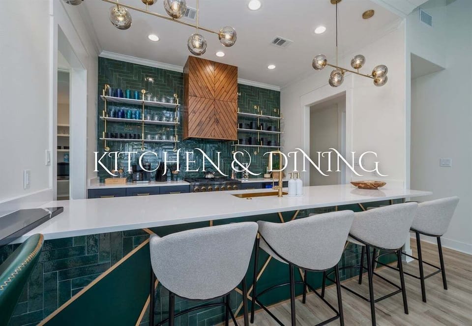 The Kitchen And Dining Area Showcases An Elegant Bar With Emerald Backsplash Tiles And Gold Accents, Emphasizing A Modern And Sophisticated Space.