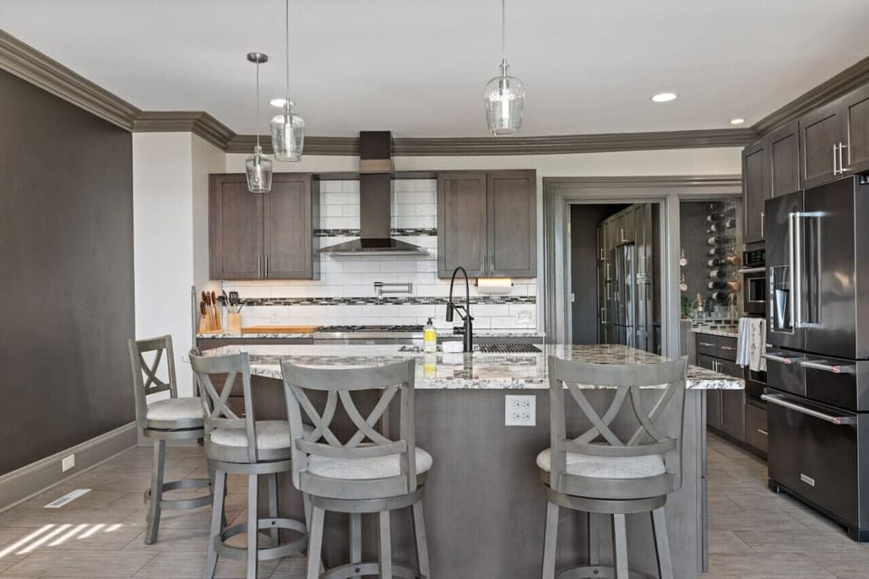 Socialize with ease with swivel bar stools--view of the living room, kitchen, and 65` OLED Smart TV