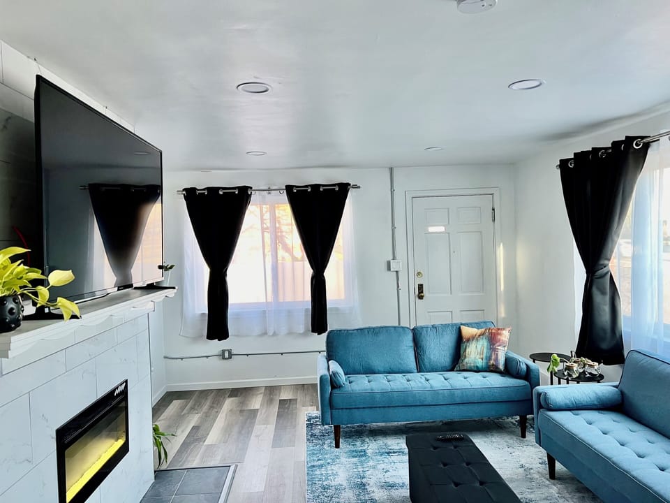 Upstairs living area with electric fireplace, 65” Smart Fire TV and dining area.