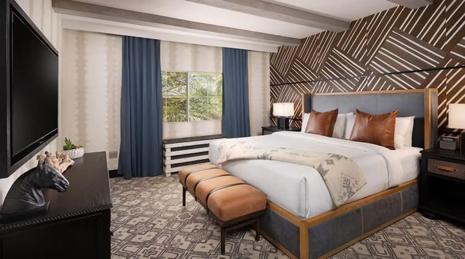 Sink into a luxe king bed beneath dramatic designer walls.