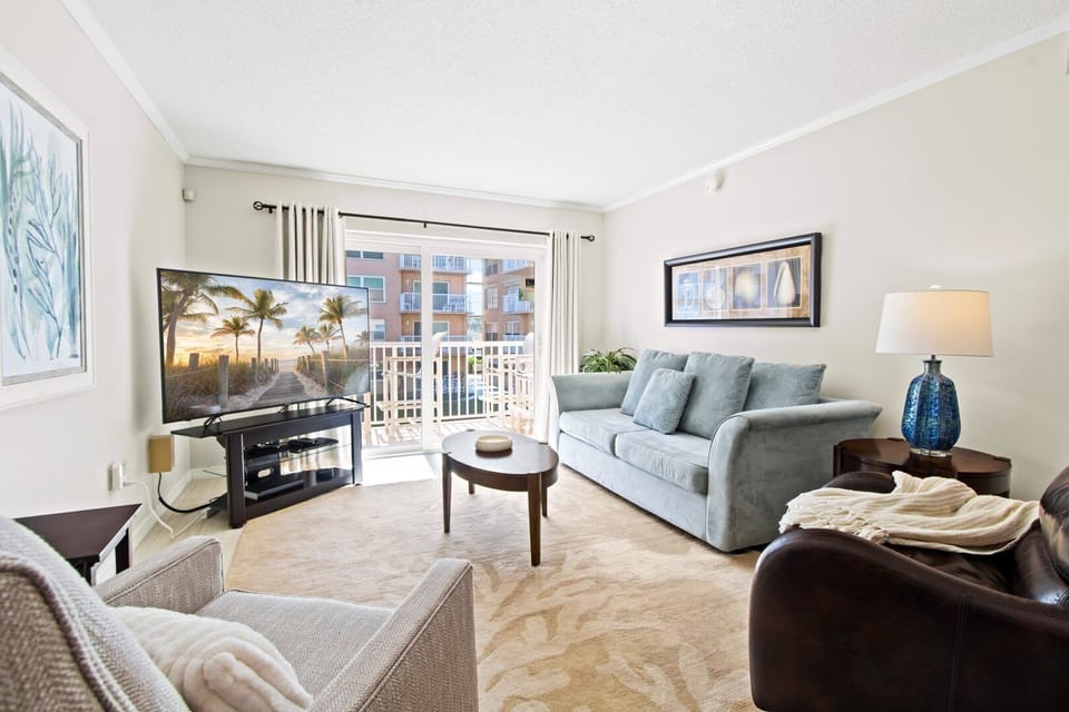 Bright & airy living room with sliding glass doors that lead to private balcony