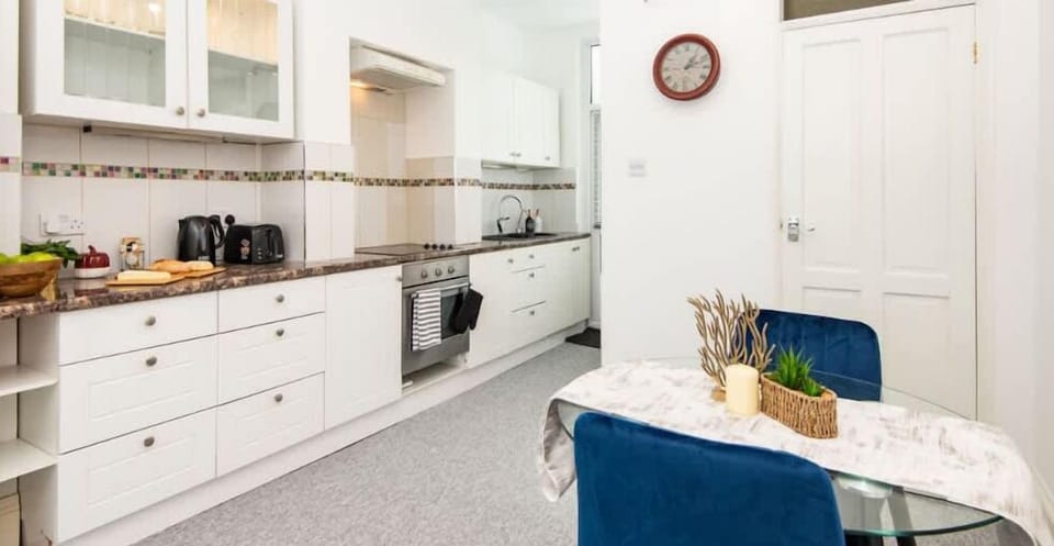 Fully equipped kitchen with a stove, microwave, kettle, oven, toaster.