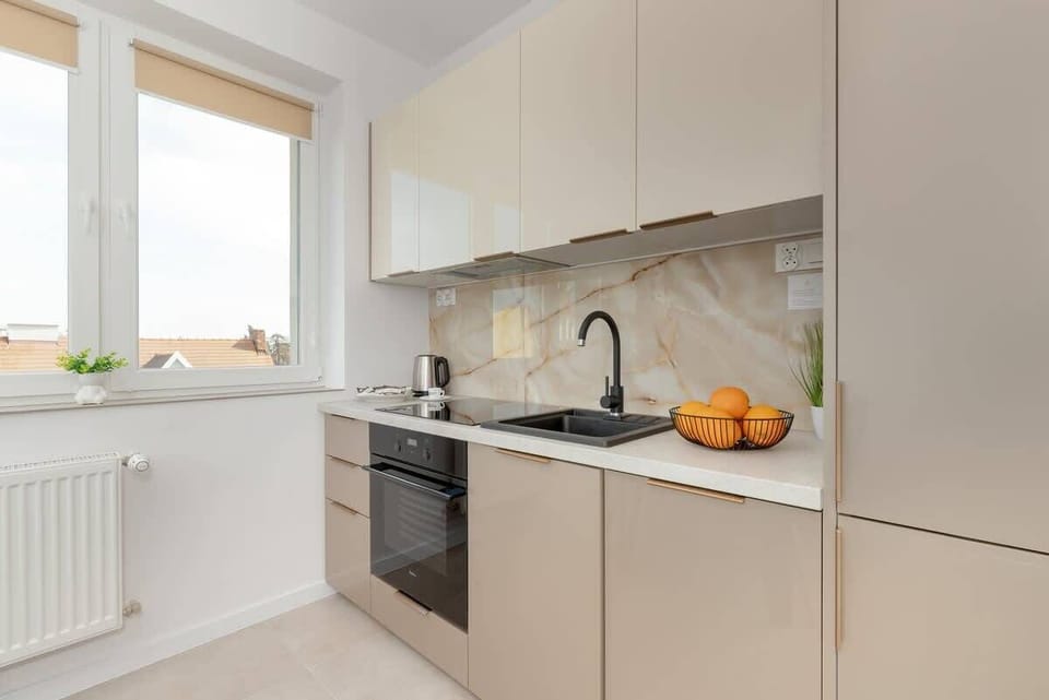 The kitchen's sleek design includes all necessary cookware and utensils. 