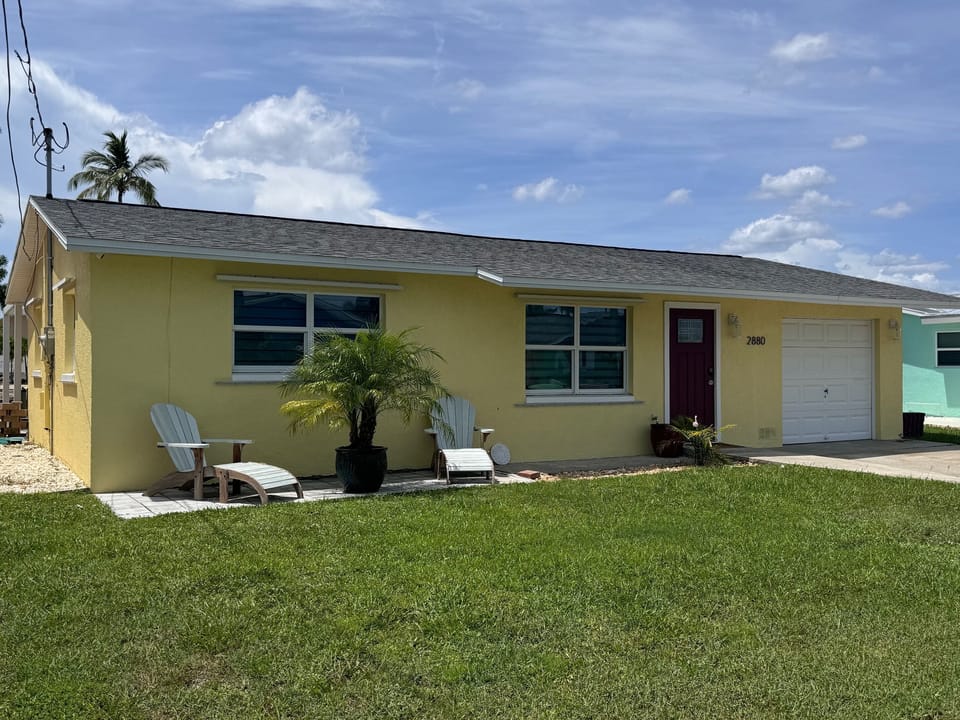 Front of home with plenty of parking for boat trailer in yard and cars in driveway