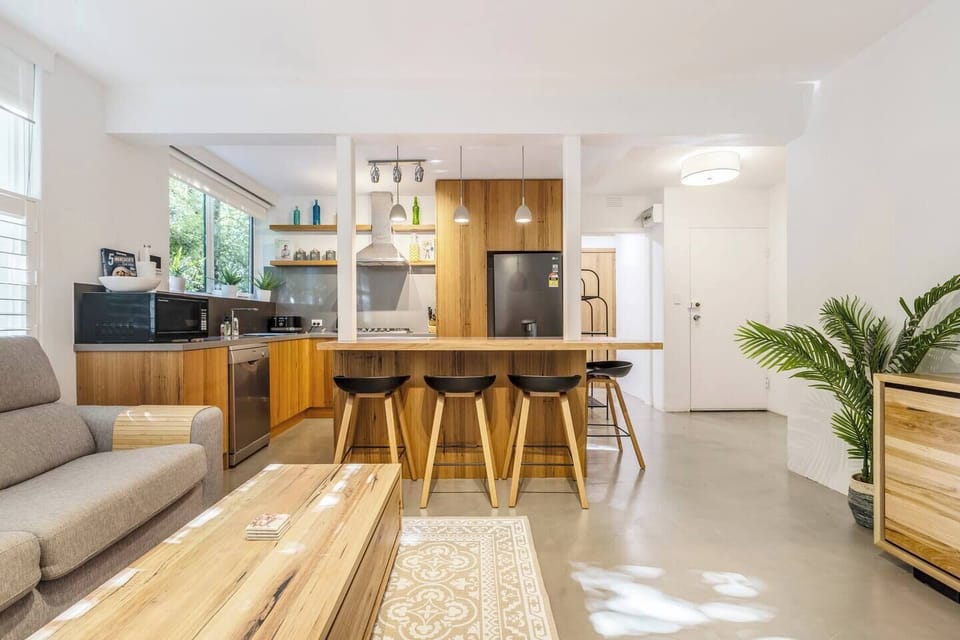 The kitchen is designed around a central island, with breakfast bar seating for slow mornings at home.
