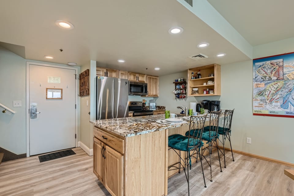Modern kitchen with stainless steel appliances and a breakfast bar.