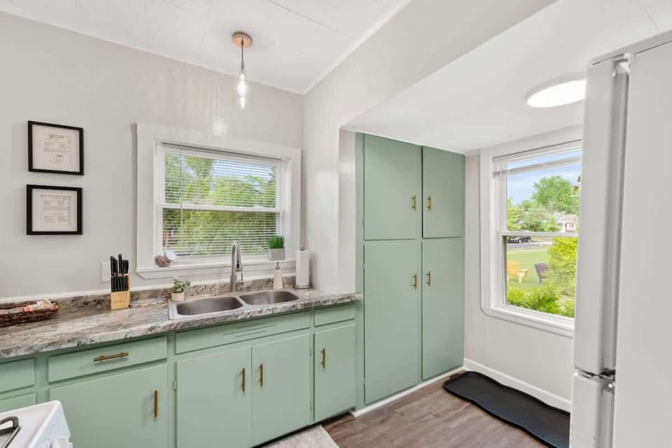 Bright kitchen w/ mint cabinetry, classic stove & cheerful natural light