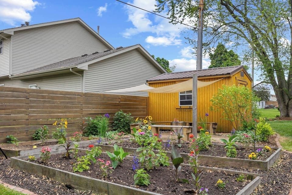 A garden full of color will grow up throughout the summer and create a hidden gem of beauty. This yard offers beauty in all seasons with lots of little places to relax and enjoy nature.