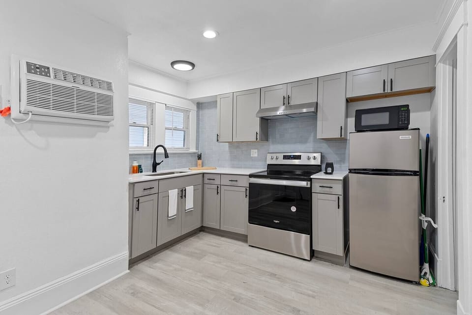 Kitchen equipped with an oven, stovetop, microwave, refrigerator, and all the essential utensils and cookware needed for preparing meals.