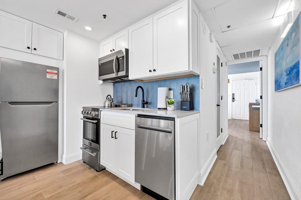 Stainless steel appliances, quartz countertops and cooking/dishware 