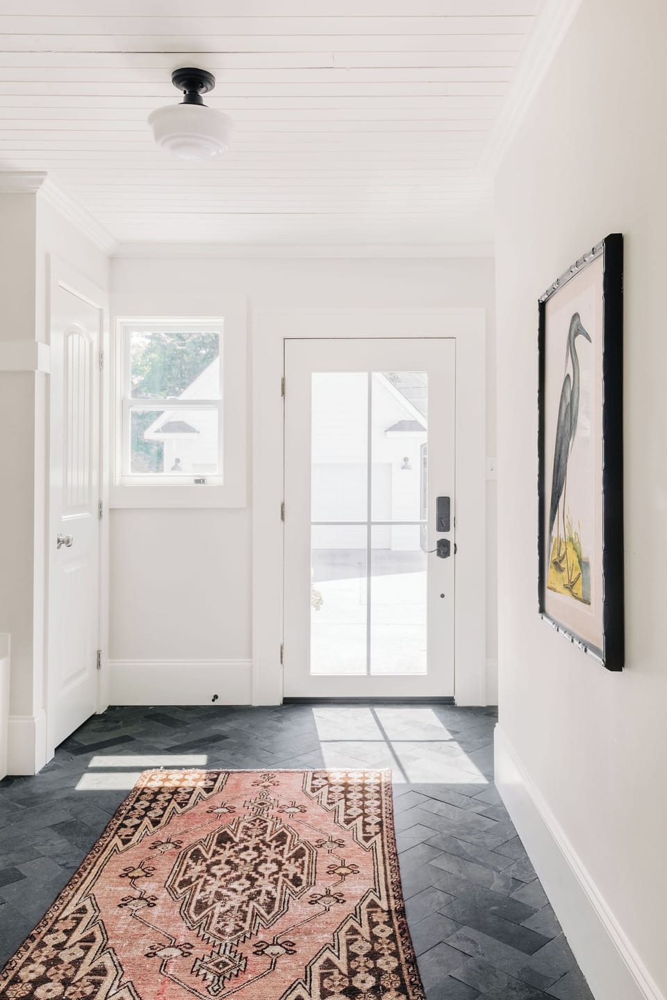 Laundry room with herringbone tile, extra closet storage and a washer/dryer. 