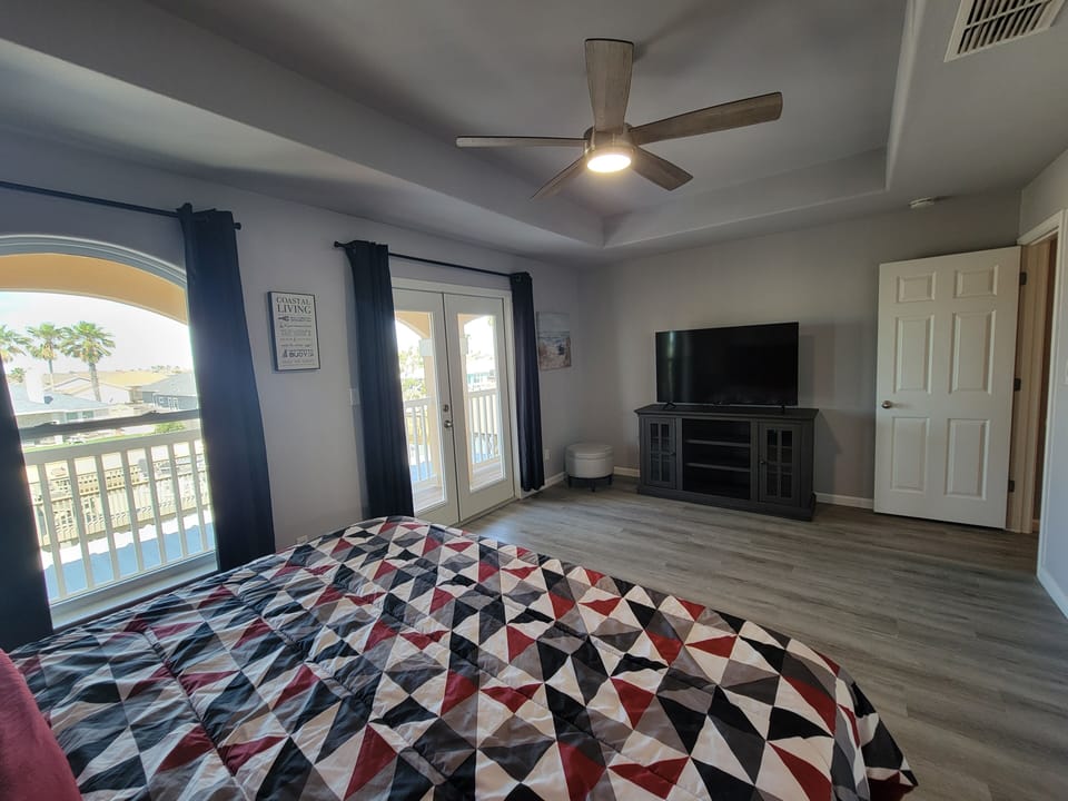 Primary room with large TV and view of backyard.