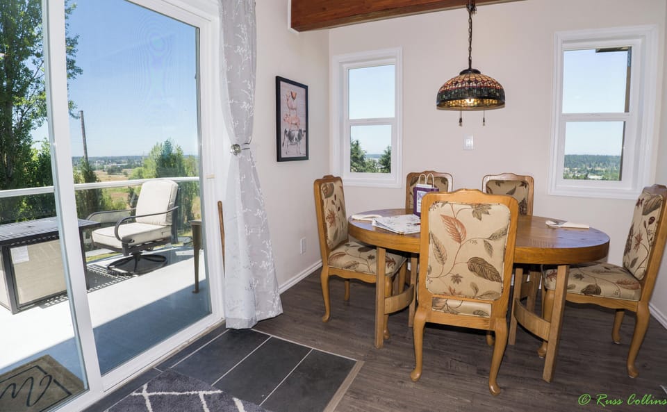 Dining area with view of patio.  Patio has a fire table with chairs and barbeque