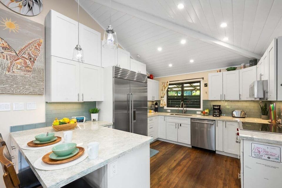 Fully equipped kitchen with modern and stainless steel appliances and white cabinetry for your convenience