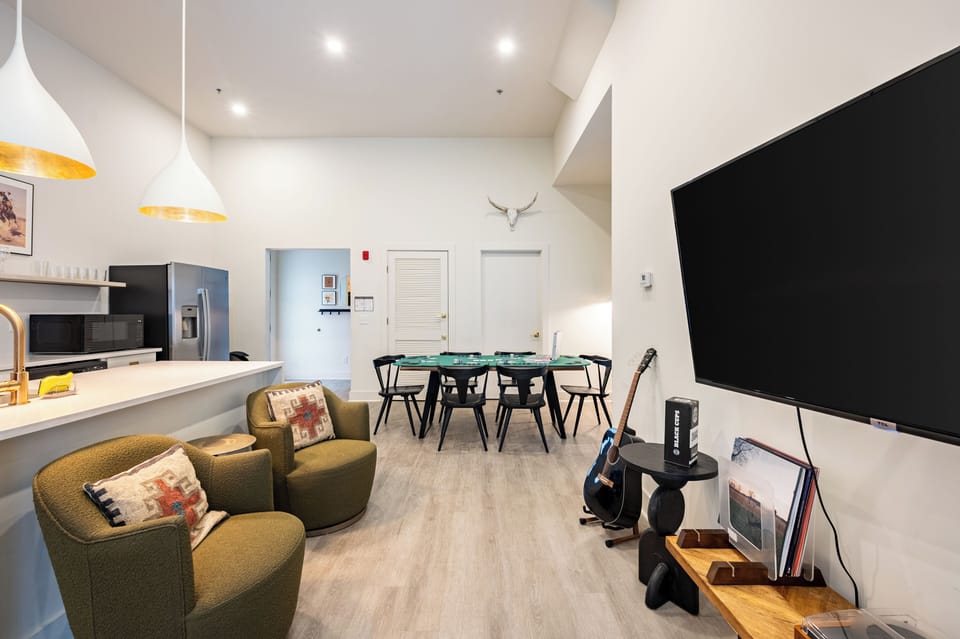 Cozy living room with plush seating, TV, and guitar.