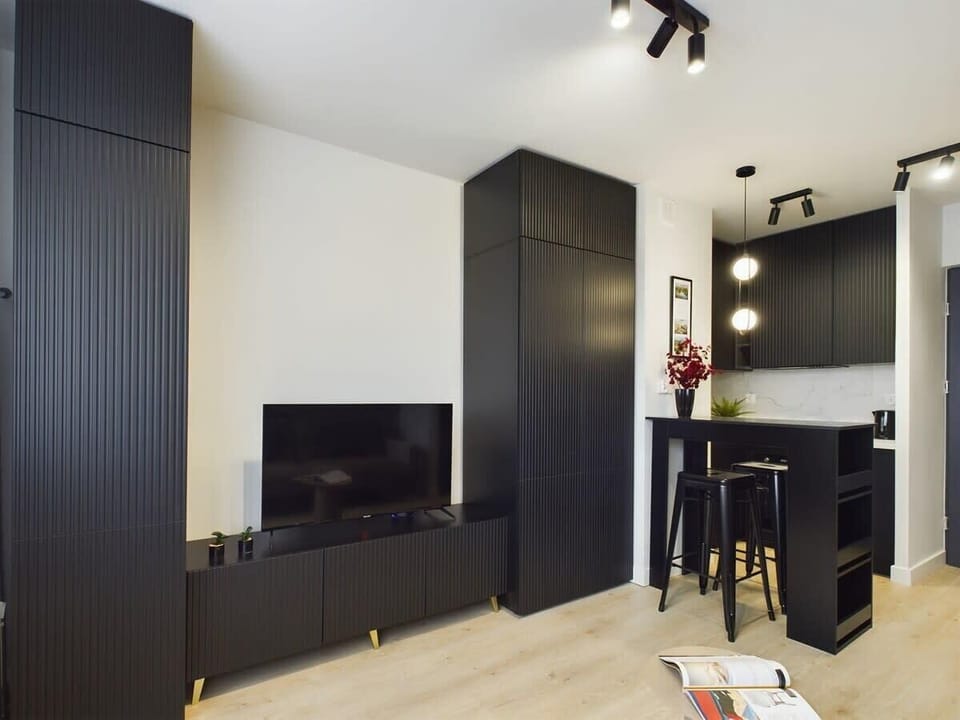 A dark cabinet with a small appliance and a small table with a chair. The space is compact and efficiently organized.