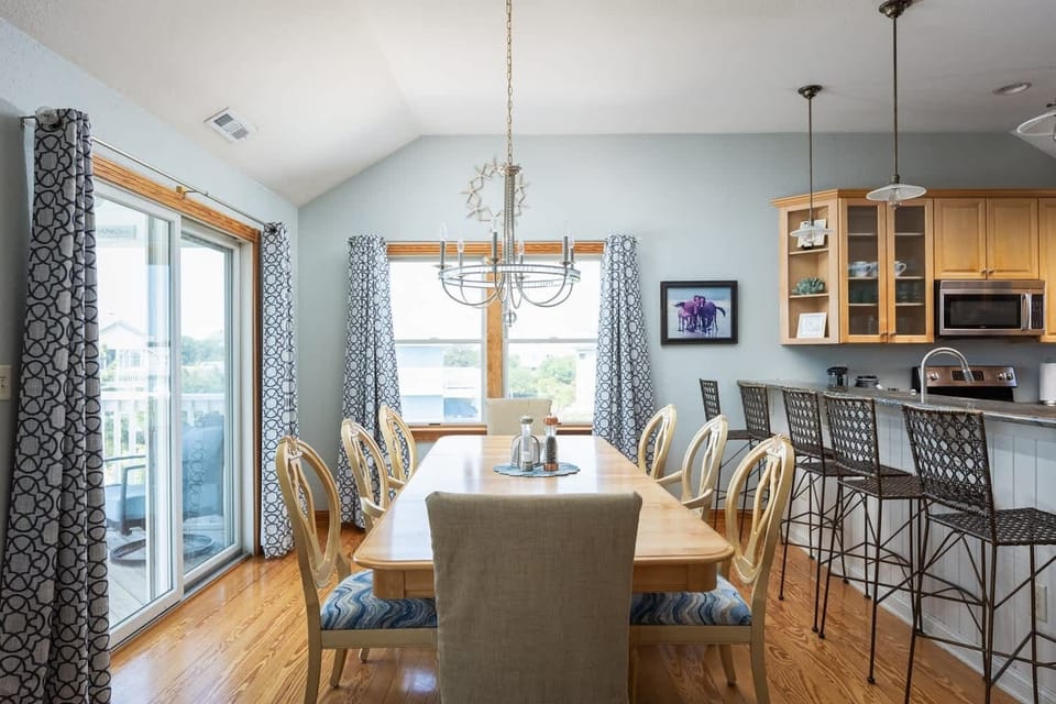 Dining Area with seating for the whole group and beautiful natural light, connected to the kitchen island with bar seating