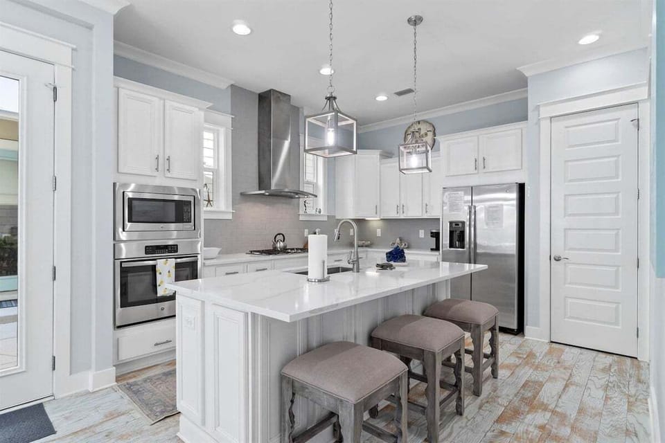 An open-concept kitchen with a large island, modern pendant lighting, and top-tier appliances.
