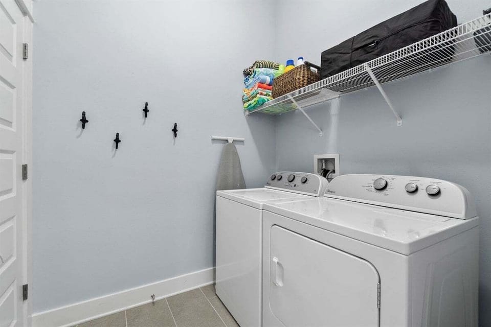 A convenient laundry setup with ample storage and fresh, clean aesthetics.
