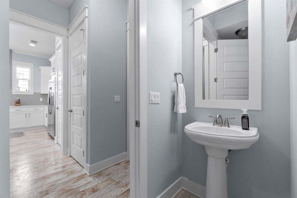 A simple and elegant powder room with a pedestal sink and fresh decor.