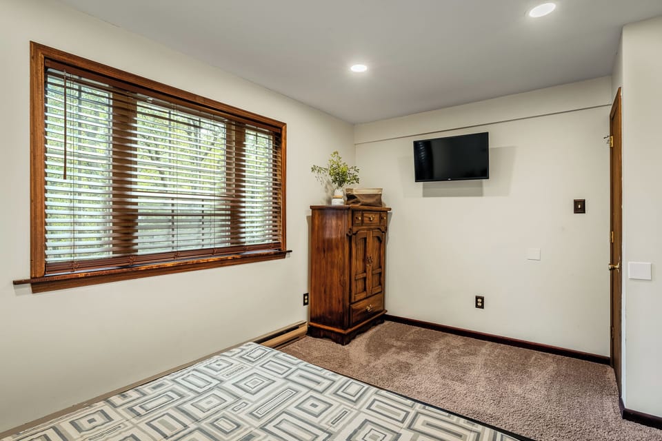 Bedroom 2 features a queen bed and a TV.
