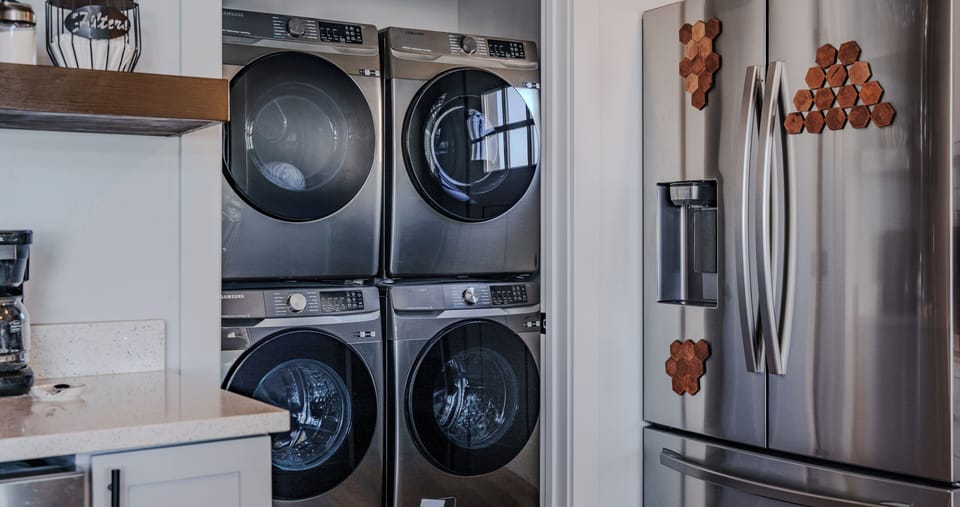 Two washers and driers in the mudroom